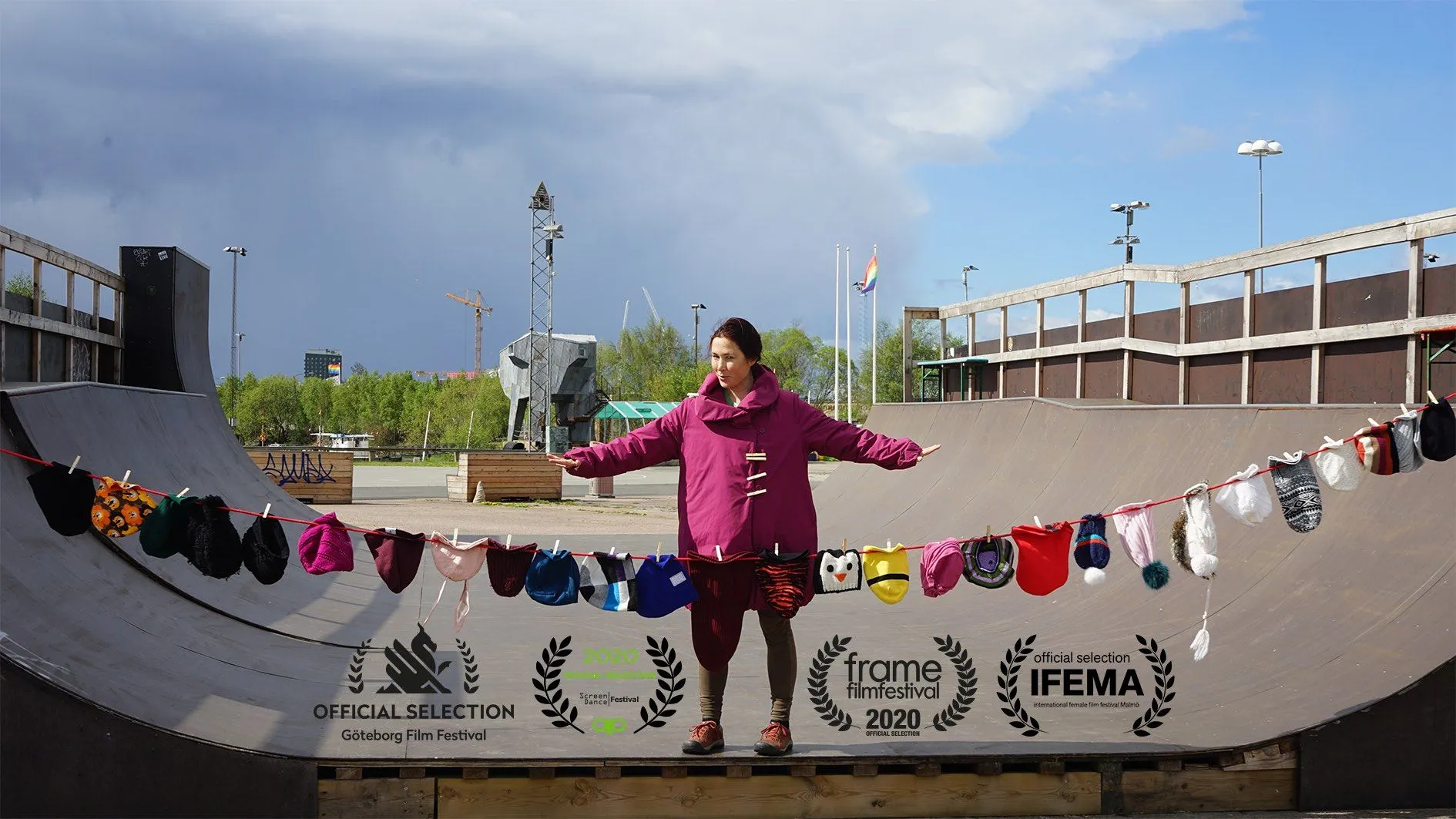 Stine i en performance på en skateramp, med tvättlinor av små plagg uppspända framför sig.